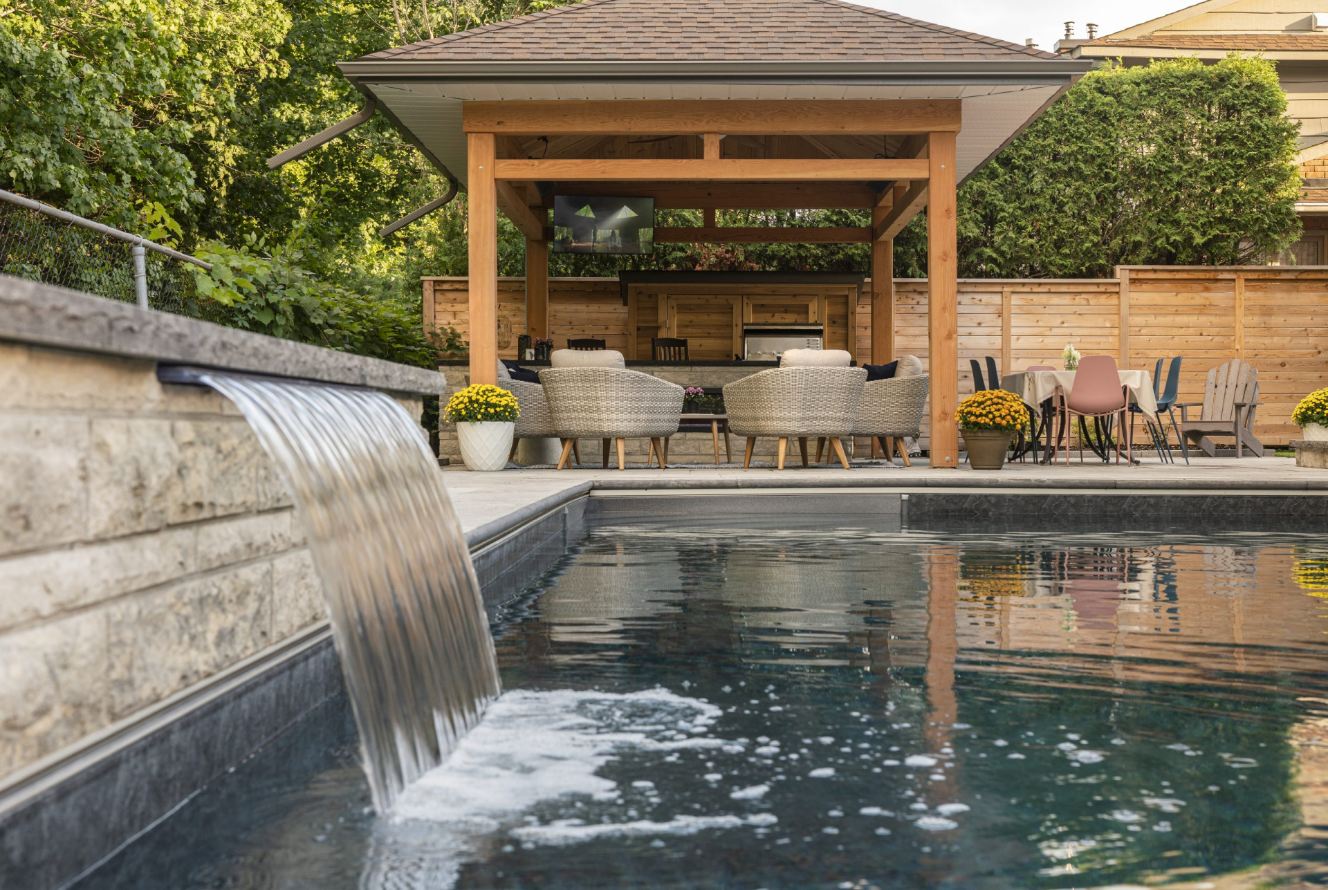 Backyard and pool designed by Mallette Landscaping with waterfall